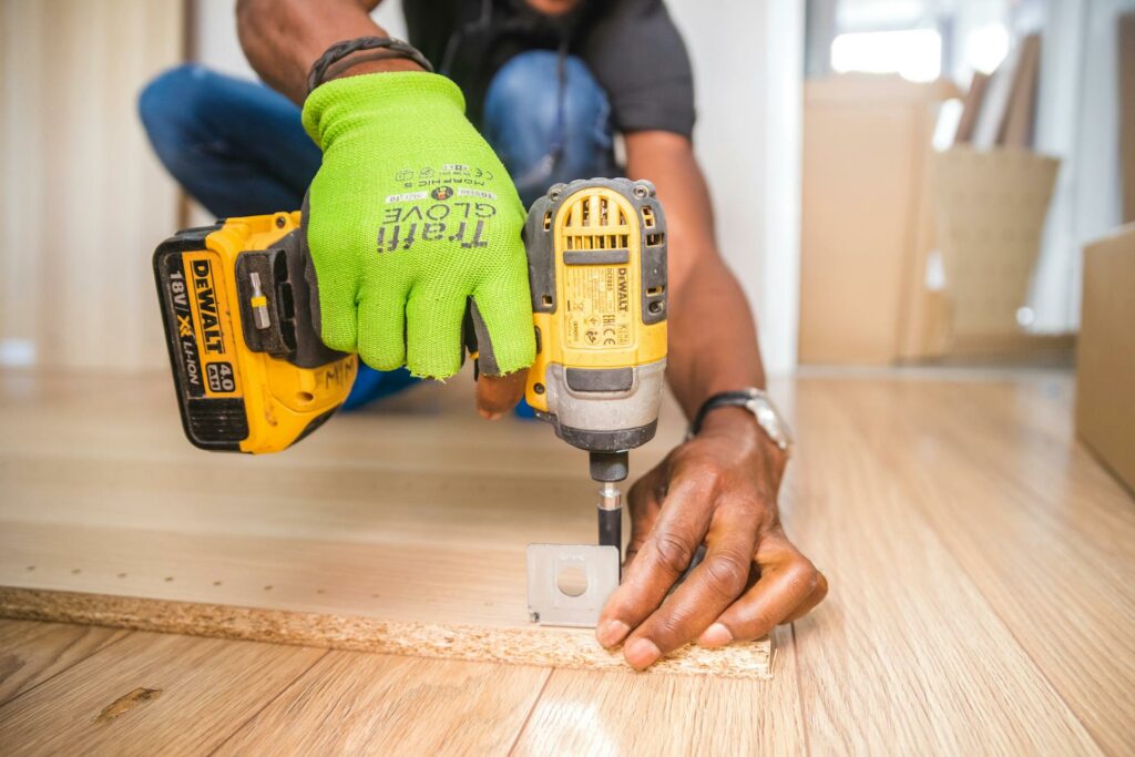 using a drill to screw a bracket on a board