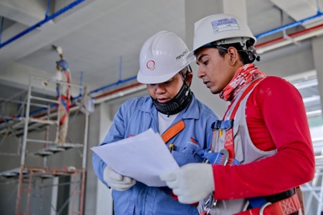 a project manager speaking with a construction administrative assistant on a job site