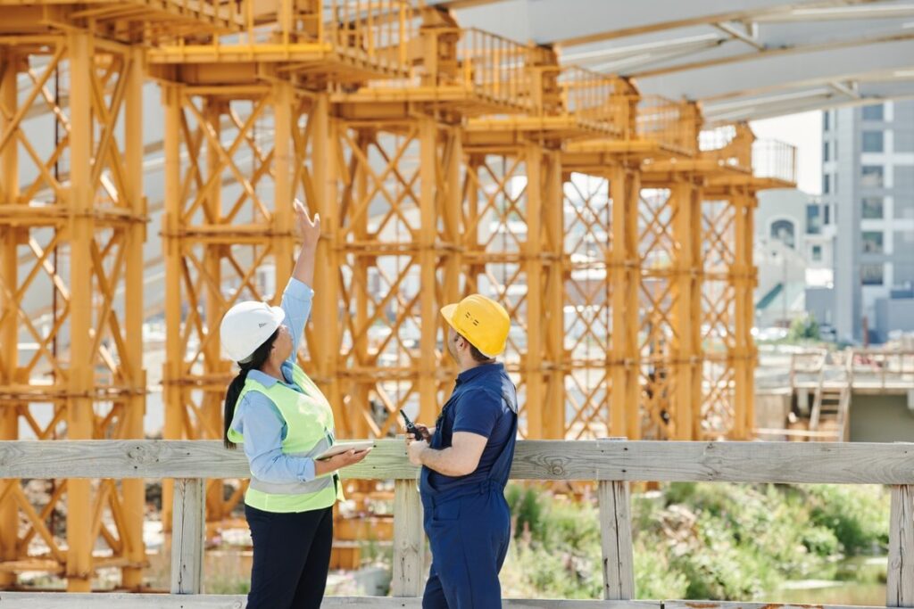 a construction manager and worker discussing the completion of a construction project milestone on a job site