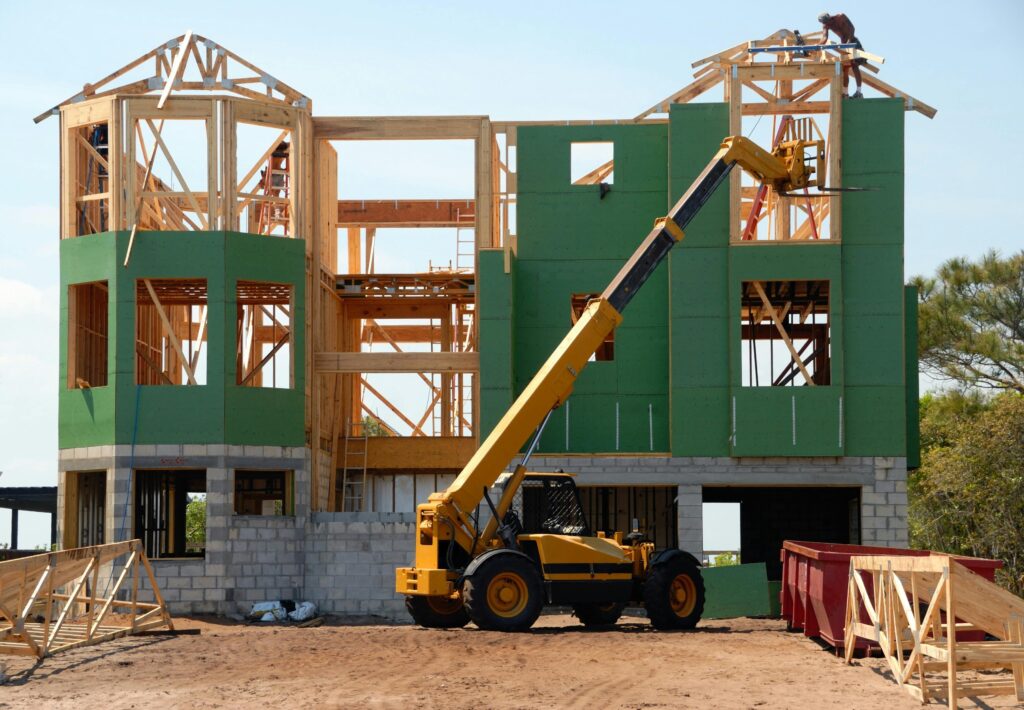 a house under construction with heavy equipment in front