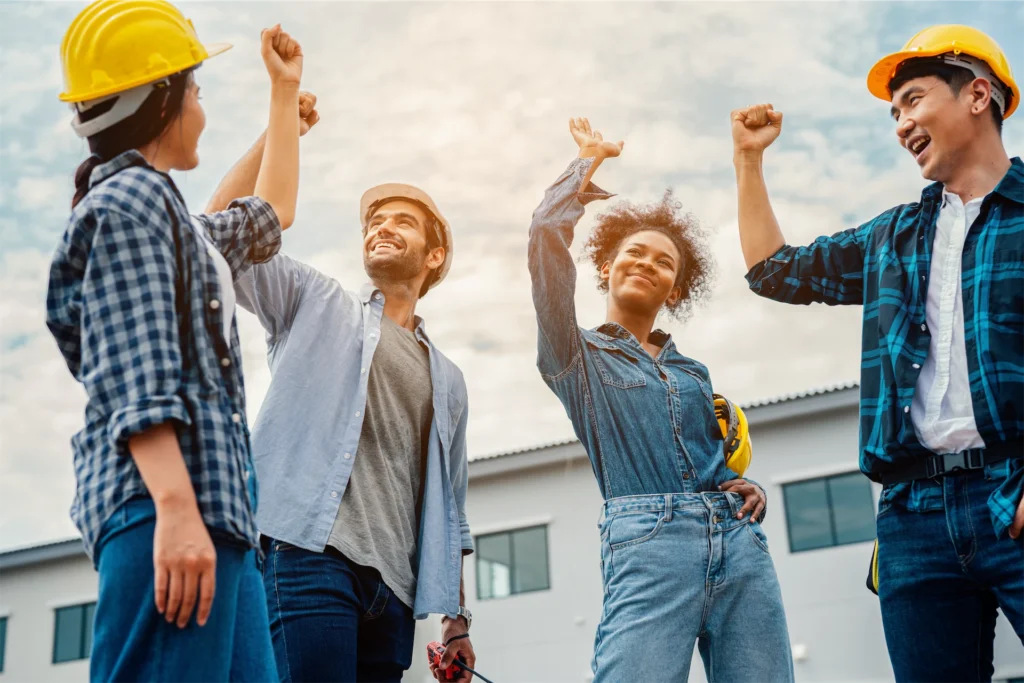 Workers cheering together to mark a masonry milestone during progress on a commercial construction site