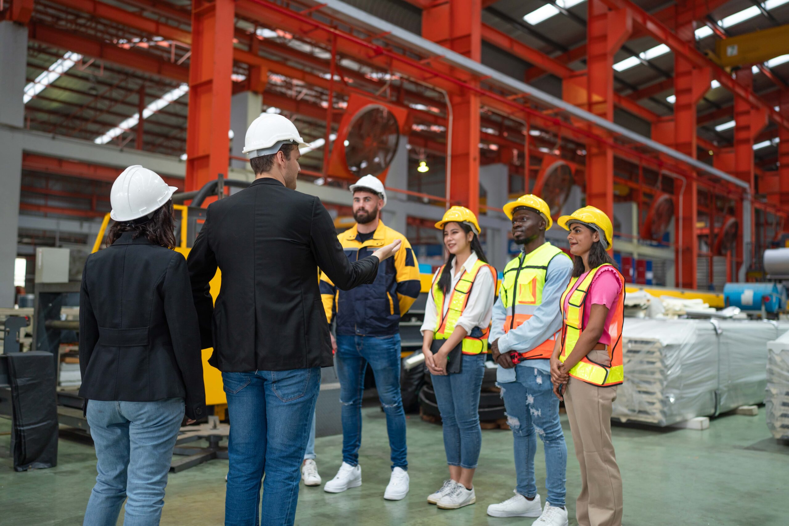 Construction manager briefing team in safety gear on site